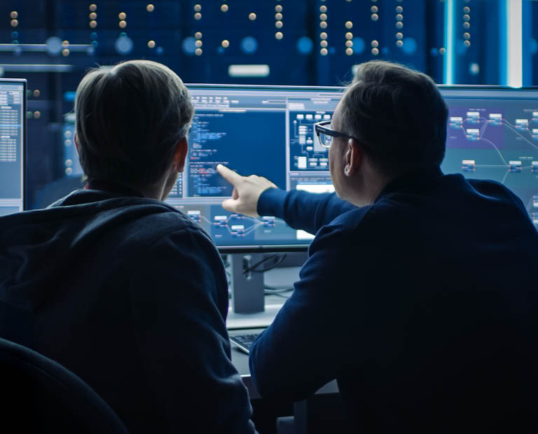 IT-medewerkers in controlekamer met meerdere schermen en serverracks, symbool voor proactief IT-beheer